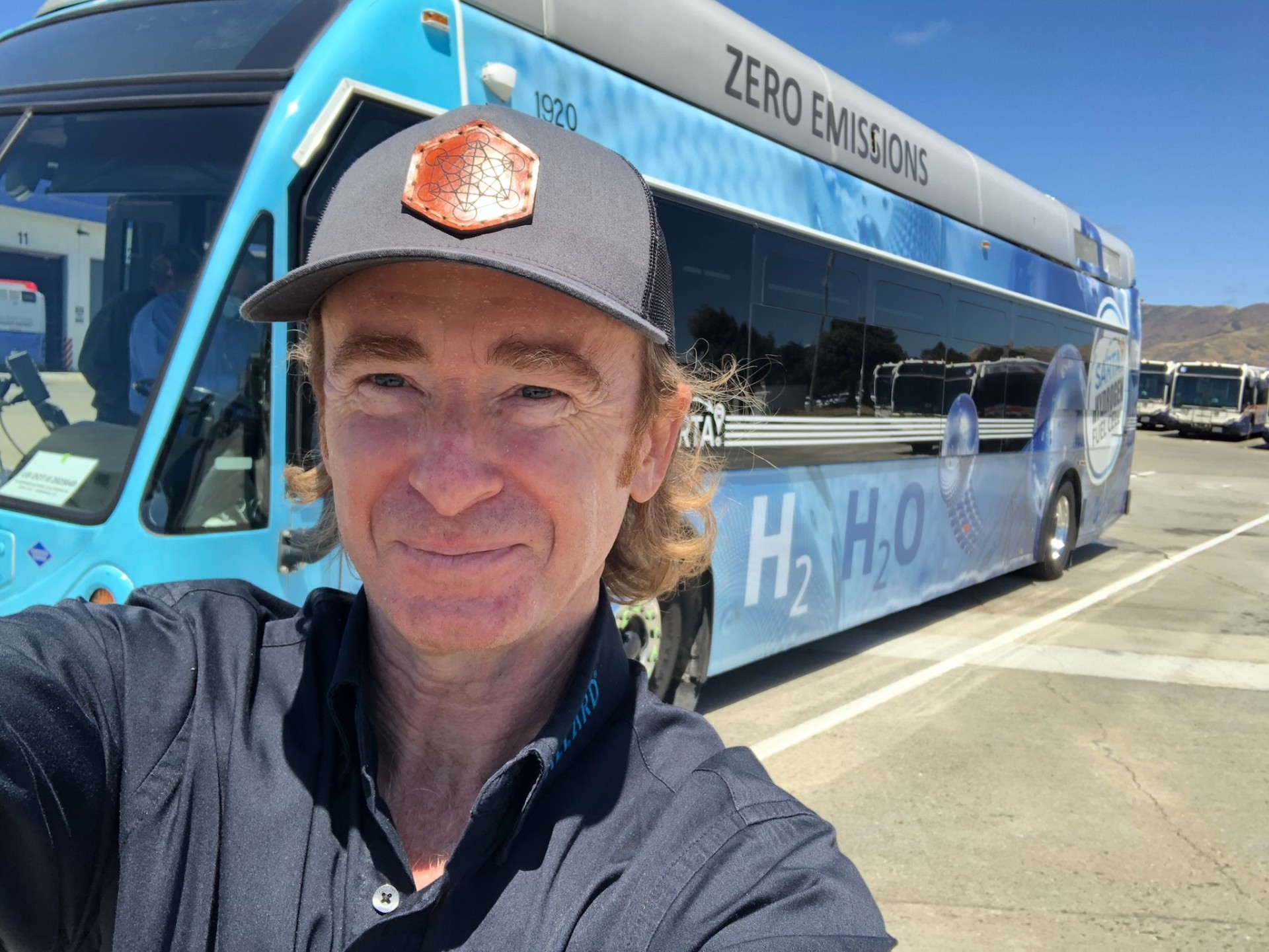 Tim beside a SunLine Transit hydrogen fuel cell bus